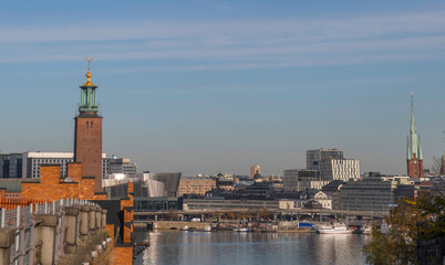 Fototapeta premium Hill view over the Town City Hall and the down town district at the Central Station waterfront pier with steam commuting boats an sunny autumn day in Stockholm