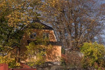 Details of old 1700s houses, autumn colored trees an sunny autumn day in Stockholm