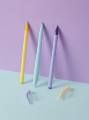Modern and creative composition with multicolored pens on a two tone pastel background. Minimal still life. Business, education concept