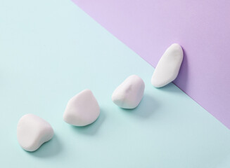 Pebbles on a pastel background. Minimal still life