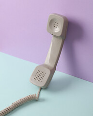 Creative retro 80s layout with phone tube on pastel background. Conceptual pop. Minimal still life