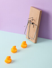Creative layout, mousetrap with rubber ducks on pastel background. Conceptual pop. Minimal still...