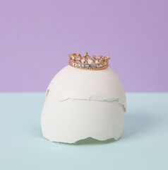 Creative layout. Golden crown with eggshell on two tone pastel background. Conceptual pop. Minimal...