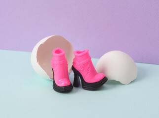 Creative layout. Doll boots with eggshell on two tone pastel background. Conceptual pop. Minimal fashion still life.