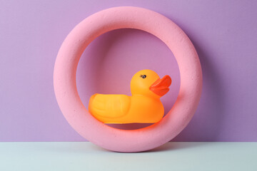 Creative layout with rubber duck and pink round on pastel background. Conceptual pop. Minimal still life