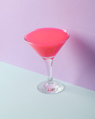 Creative layout, cocktail glass with neon slime on two tone pastel background. Visual trend. Minimalistic aesthetic still life. Party concept. Fresh idea