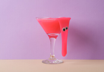 Creative layout, cocktail glass with neon slime and eyes on two tone pastel background. Visual trend. Minimalistic aesthetic still life. Party halloween concept. Fresh idea