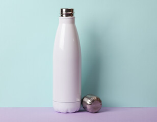 Thermos bottle on two tone pastel background.