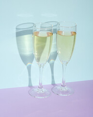 Creative layout with champagne glass on two tone pastel background. Visual trend. Minimalistic aesthetic still life. Romantic date, holiday