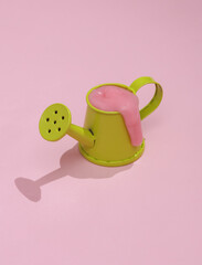 Creative layout, toy watering can with slime on pink background with shadow. Visual trend. Fresh idea. Concept pop © splitov27