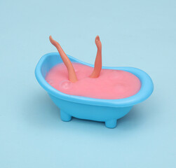 Creative layout with Doll hands in the bath on bright blue background. Visual gashion trend. Minimalistic aesthetic still life. Fresh idea