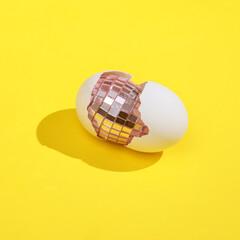 Creative layout with Mirror egg and shell. Bright yellow background with shadow. Easter concept. Visual trend. Minimalistic aesthetic still life. Fresh idea