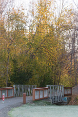 Empty pedestrian bridge at entrance of suburban park with colorful fall foliage in Anchorage, Alaska