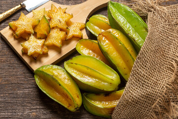 organic carambola asian fruit, star fruit, grown on organic farm in a wicker basket on a rustic wooden table top view with space for writing
