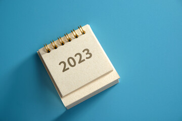 top view of 2023 desk calendar against blue background