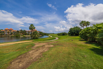 Beautiful panoramic view of hotel grounds with golf course on blue sky with white clouds in background. Aruba. 