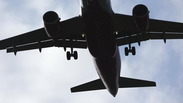passenger airplane flies overhead, lands at the airport