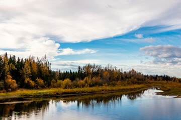 Fototapeta na wymiar Red Deer River flows past the fall colours. Red Deer County, Alberta, Canada