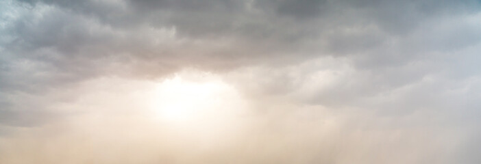 Dramatic Sky Background with sunny beams. Panoramic view of Stormy Clouds in Dark sky