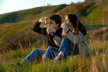 The concept of young people having a happy and fun time at a picnic in nature during the warm season.