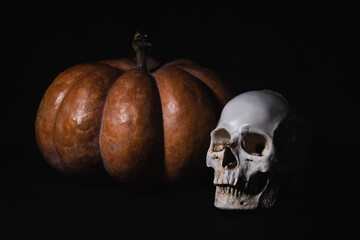 dynia i czaszka na czarnym tle jako kompozycja na Halloween