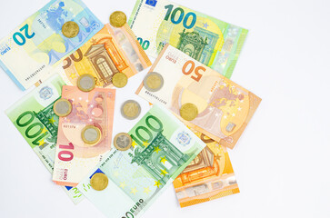 Different paper banknotes of euros and coins of cents on a white background with a place.