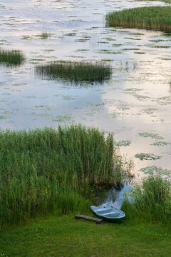 Lake Lubans, the biggest lake in Latvia. Shallow drainage lake, fed by the Rēzekne, Malta, Malmuta and Lisinja rivers, several smaller brooks, ponds, reeds, white water lilies, with reflections, boat