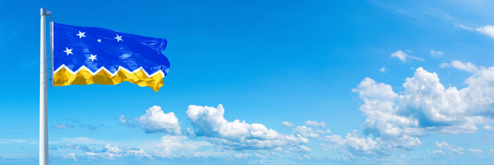 Magallanes Region flag waving on a blue sky in beautiful clouds - Horizontal banner
