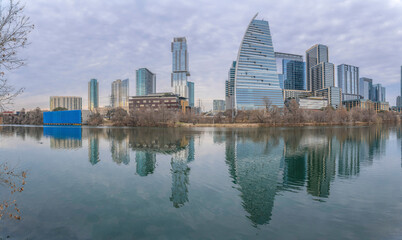 Fototapeta na wymiar Austin Texas city skyline reflected on the calm pond water against cloudy sky