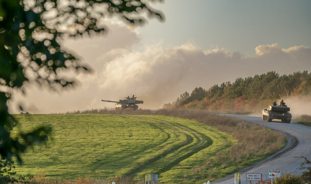 British army FV4034 Challenger 2 ii main battle tanks descend a country track to a road crossing, Wiltshire UK