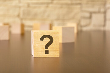 natural wooden cube with question marks, black background