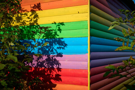 Colourful wooden panels of a rainbow painted beach hut