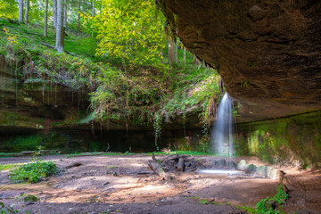 natürlicher Wasserfall mit Steinen und grünen Moos
