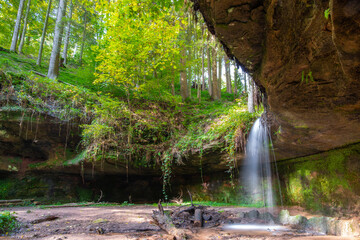 natürlicher Wasserfall mit Steinen und grünen Moos