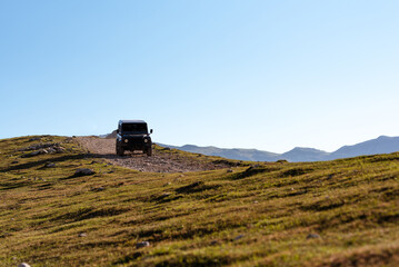 off-road black car driving on a dirt track in the mountains. car adventure trip