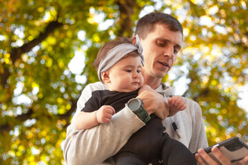 Fototapeta premium Happy father play with the baby. The man holding the toddler in the hands and have fun