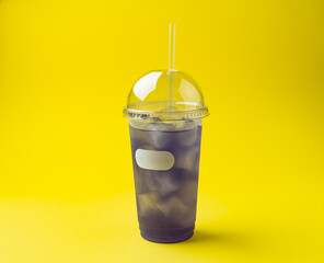 lemonade with lavender in a plastic glass with a straw on a yellow background
