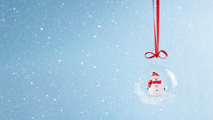 Transparent christmas bauble with snowman inside. Stock image with copy space