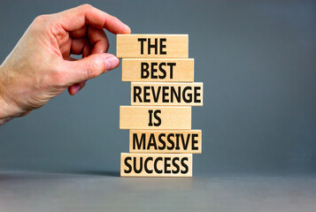 Revenge or success symbol. Concept words The best revenge is massive success on wooden blocks. Bussinesman hand. Beautiful grey background. Business and revenge or success concept. Copy space.