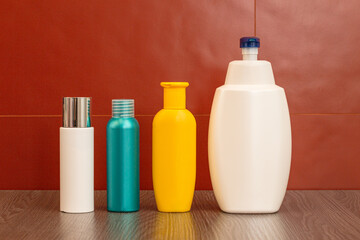 Containers and bottles of different sizes, shapes and colors for cleanser, tonic, conditioner, soap and shampoo on a red background in the bathroom. Natural organic cosmetics, packaging with an empty.