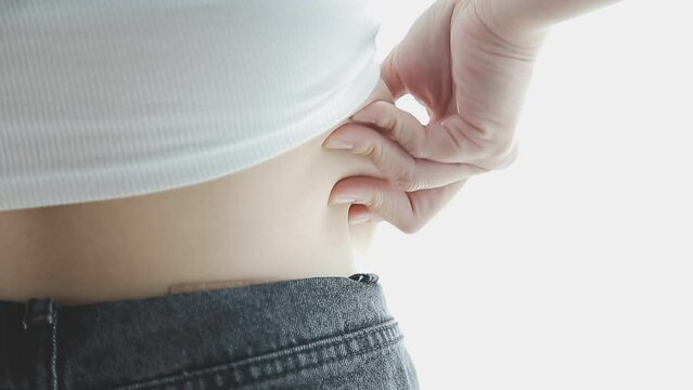 Beautiful fat woman with tape measure She uses her hand to squeeze the excess fat that is isolated on a white background. She wants to lose weight, the concept of surgery and break down fat under the