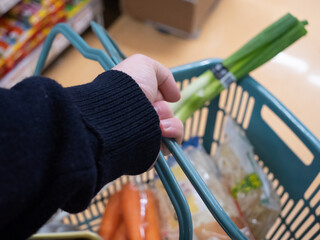 A young man's hand holding a shopping basket - 540138175