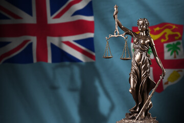 Fiji flag with statue of lady justice and judicial scales in dark room. Concept of judgement and...