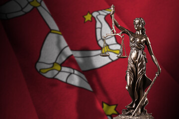 Isle of Man flag with statue of lady justice and judicial scales in dark room. Concept of judgement...