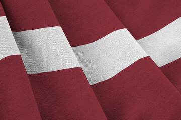 Latvia flag with big folds waving close up under the studio light indoors. The official symbols and...