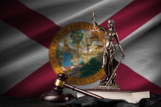 Florida US state flag with statue of lady justice, constitution and judge hammer on black drapery. Concept of judgement and guilt