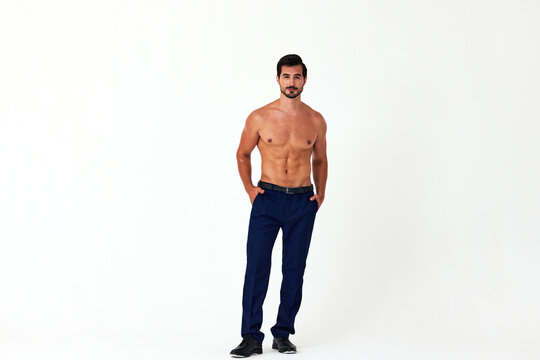 Man with bare torso and prue cubes in business pants shows full-length nude body, women's day March 8 on white isolated background copy space 