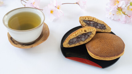 Obraz na płótnie Canvas 和菓子のどら焼きと緑茶｜桜と春のイメージ