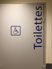 illustration d'une porte grise ou il est inscrit que ce sont des toilettes réservée aux handicapées en couleur bleu