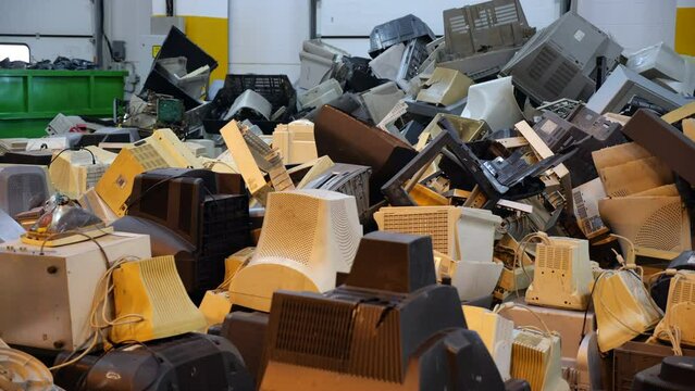 A bunch of old plastic cases from office monitors with kinescopes. A mountain of junk plastic electronics parts for recycling. Dump of technical and electrical equipment.